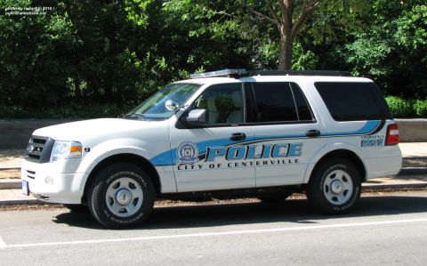 2006 Ford F-150 - A white police SUV with blue accents is parked on the side of the road.