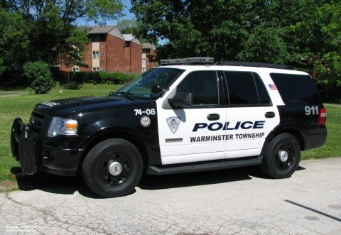 2006 Ford F-150 - A black and white police SUV, marked 'POLICE WARMINSTER TOWNSHIP', is parked on a paved surface with trees and buildings in the background.
