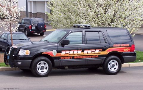 2006 Ford F-150 - A black police SUV with West Greenwich markings is parked on a street, with other vehicles and flowering trees in the background.