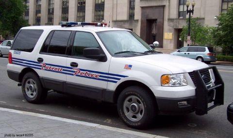 2006 Ford F-150 - This white police SUV, marked 'Detroit Police', features a push bumper and emergency lights on its roof.