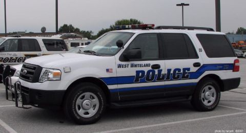 2006 Ford F-150 - A white 2006 Ford F-150 police SUV is parked in a lot next to another police vehicle.
