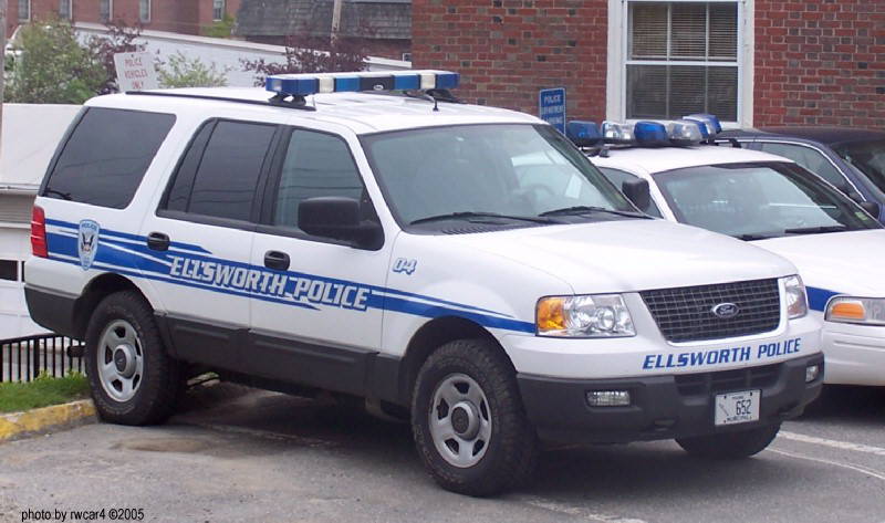 White Ford Expedition police SUV with blue light bar, side markings 'ELLSWORTH POLICE'