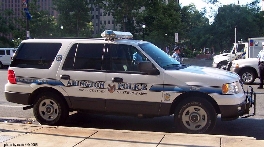 Side view of white Abington Police SUV with "OF SERVICE - 2006" text