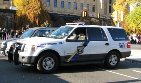2006 Ford F-150 - A police SUV is parked on the street, with 'TRUCK ENFORCEMENT' and 'DIAL 911' visible on its side.