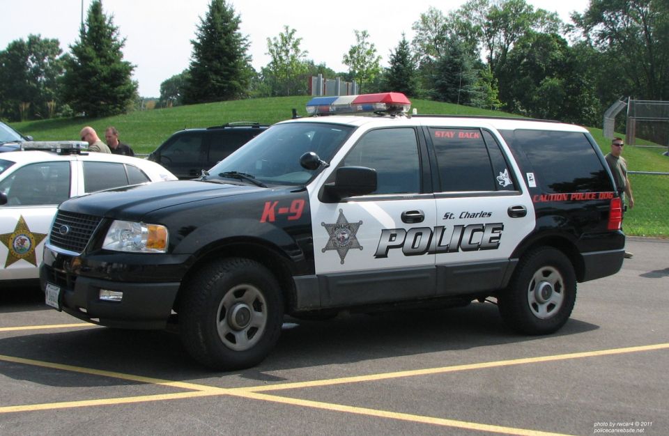 Black and white police SUV with K-9 markings, parked in a lot