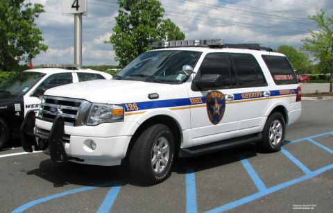 2006 Ford F-150 - This white sheriff SUV, marked 'Essex 126', is seen parked in a lot next to another police vehicle.