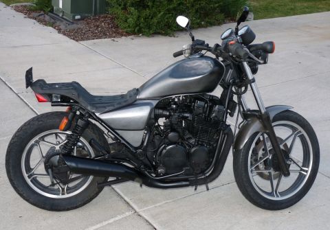2002 Kawasaki Ninja - Motorcycle with custom seat and paint parked on a sidewalk.