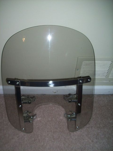 2006 Harley-Davidson Sportster Custom - A tinted motorcycle windshield with chrome hardware is shown resting on a carpeted floor.