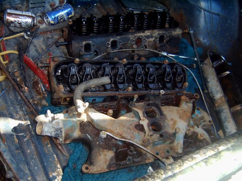 1982 Ford Bronco - Close-up view of a disassembled engine, showing internal components and surrounding debris.