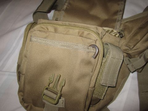 1990 Ford Bronco - Close-up of a tan tactical pouch, showing zippers, a metal D-ring, and a plastic buckle.