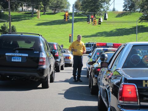 1991 Ford LTD Crown Victoria - man in a yellow shirt stands in the road between a black Acura MDX and dark patrol cars with light bars.