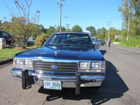 1991 Ford LTD Crown Victoria - Front view of a blue Ford sedan with a front push bar and a New Hampshire license plate reading 299 7649 in a parking lot.