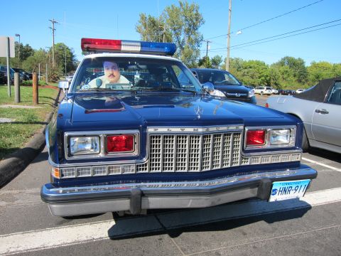 1991 Ford LTD Crown Victoria - Front view of a blue Plymouth police sedan with a roof light bar and a Connecticut license plate reading HNR-911.