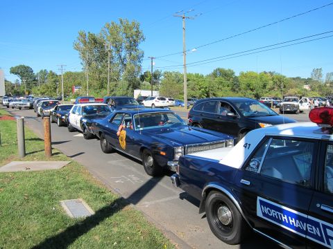 1991 Ford LTD Crown Victoria - row of classic police cars parked along a curb, including a black and white NORTH HAVEN cruiser marked 41 in the foreground.