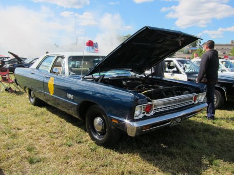 1991 Ford LTD Crown Victoria - vintage blue State Police sedan with its hood open and a gold door emblem sits on grass with a spectator nearby.