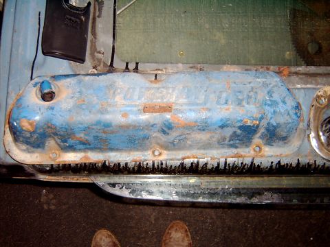 1982 Ford Bronco - Close-up of a blue engine valve cover with visible rust and "FORD" lettering.