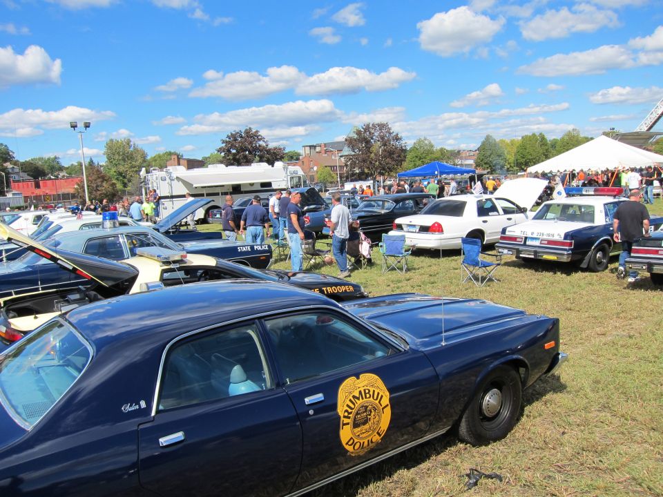 Dark blue Trumbull Police sedan with gold door emblem among police cars at show