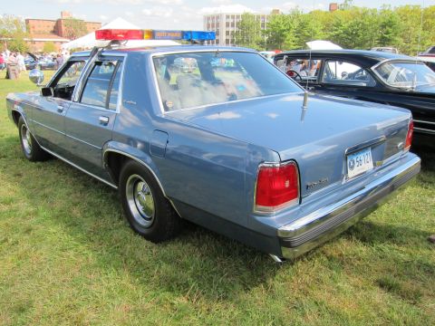 1991 Ford LTD Crown Victoria - Rear view of a light blue Ford LTD Crown Victoria police sedan with a State Police roof lightbar and Connecticut plate at a car show.