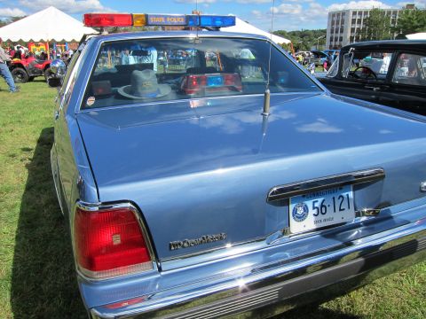 1991 Ford LTD Crown Victoria - Close rear view of a blue police sedan showing a State Police lightbar, a trooper hat on the rear deck, and a Connecticut state-vehicle pla…