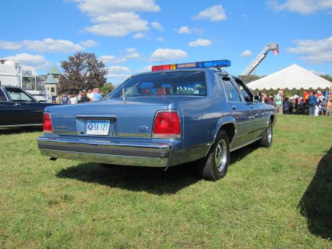 1991 Ford LTD Crown Victoria - Rear three-quarter view of a blue Ford LTD Crown Victoria police cruiser with State Police lightbar and Connecticut plate 56-121 at a car s…