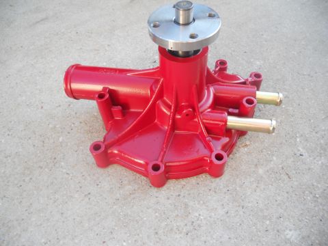 1991 Ford Bronco - A red water pump is shown against a concrete background. The part features a silver flange and shaft.