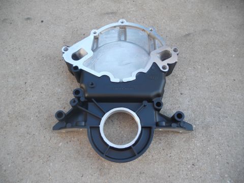 1991 Ford Bronco - This is a part for an engine, likely a timing cover, shown against a concrete surface.