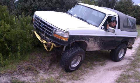 1979 Ford Bronco - Ford Bronco stuck on a dirt embankment with a yellow strap attached to the front bumper.