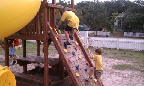 1979 Ford Bronco - Children enjoy a day of play on a wooden playground structure with a slide and climbing wall.