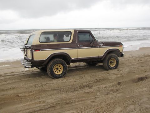 1979 Ford Bronco - Two-tone 1979 Ford Bronco parked on a sandy beach with the ocean in the background.