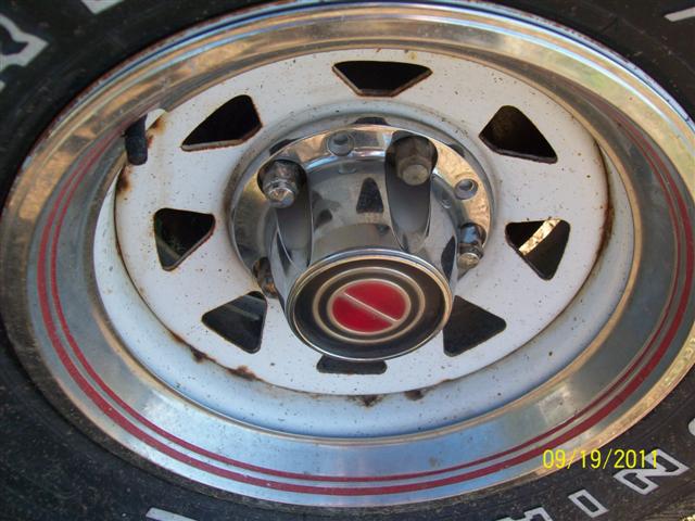 White wheel with red stripe and chrome trim, showing a chrome hubcap with a red emblem
