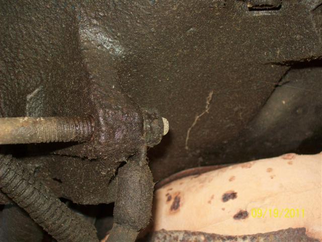 Undercarriage of a vehicle with oily components and a rusted exhaust pipe, dated 09/19/2011