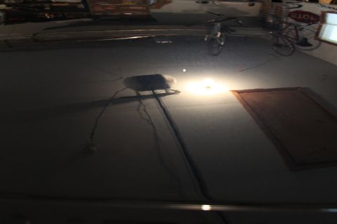 2006 Ford F-350 - Reflection on a car hood shows a bicycle and a sign that says 'STOP'.