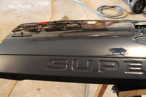 2006 Ford F-350 - Close-up of a black tailgate embossed "SUPER DUTY" lettering.