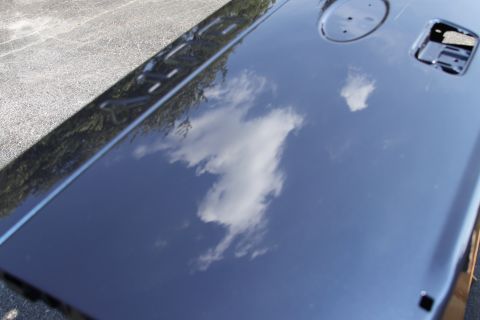 2006 Ford F-350 - Reflective dark blue tailgate, likely from a 2006 Ford F-350 Super Duty, shows cloud reflections and a SuperMotors watermark.