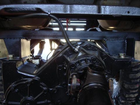 1982 Ford F-100 - Close-up of the rear differential and suspension system of a vehicle, showing various mechanical components.