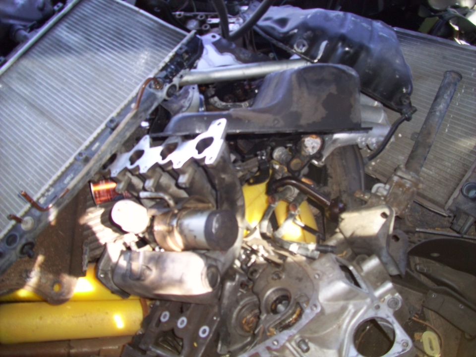 Engine block, oil pan, exhaust manifold, and radiator piled together