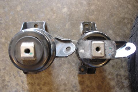 2006 Ford Fusion - Two engine mounts are shown, one appearing larger than the other, against a concrete background. The "Supermotors.net" watermark is visible.