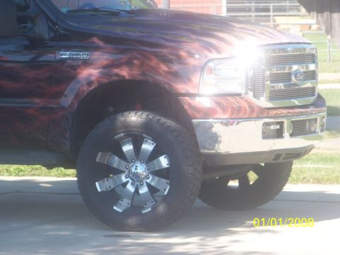 1989 Ford Bronco - Custom Ford F-350 Super Duty truck with flame graphics and aftermarket wheels.