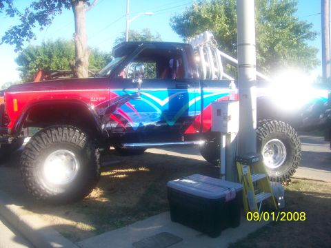 1989 Ford Bronco - This heavily modified pickup truck features custom graphics and large off-road tires, suggesting it's built for off-roading.