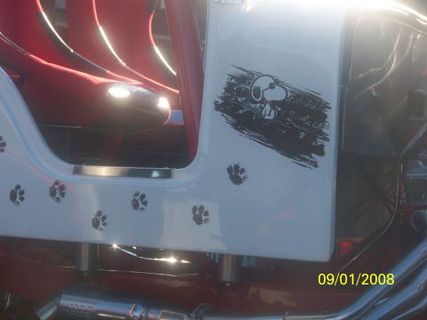 1989 Ford Bronco - This vehicle features a Snoopy decal and paw print graphics on its exterior, with red interior seats.