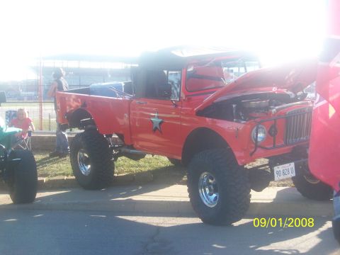 1989 Ford Bronco - This modified pickup truck has large off-road tires and its hood is open, revealing the engine compartment.
