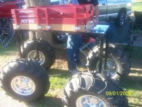 1989 Ford Bronco - Custom wagon with oversized tires sits on grass, with a pickup truck in the background.
