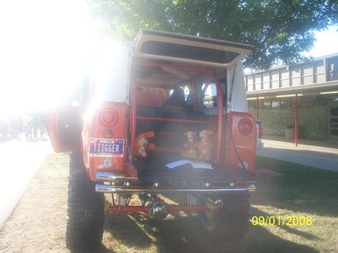 1989 Ford Bronco - Rear view of an orange SUV with its hatch open, displaying a "TIGGER" license plate and stuffed animals.