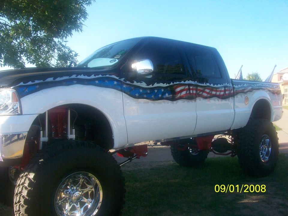 Lifted pickup truck with custom American flag paint scheme on the side