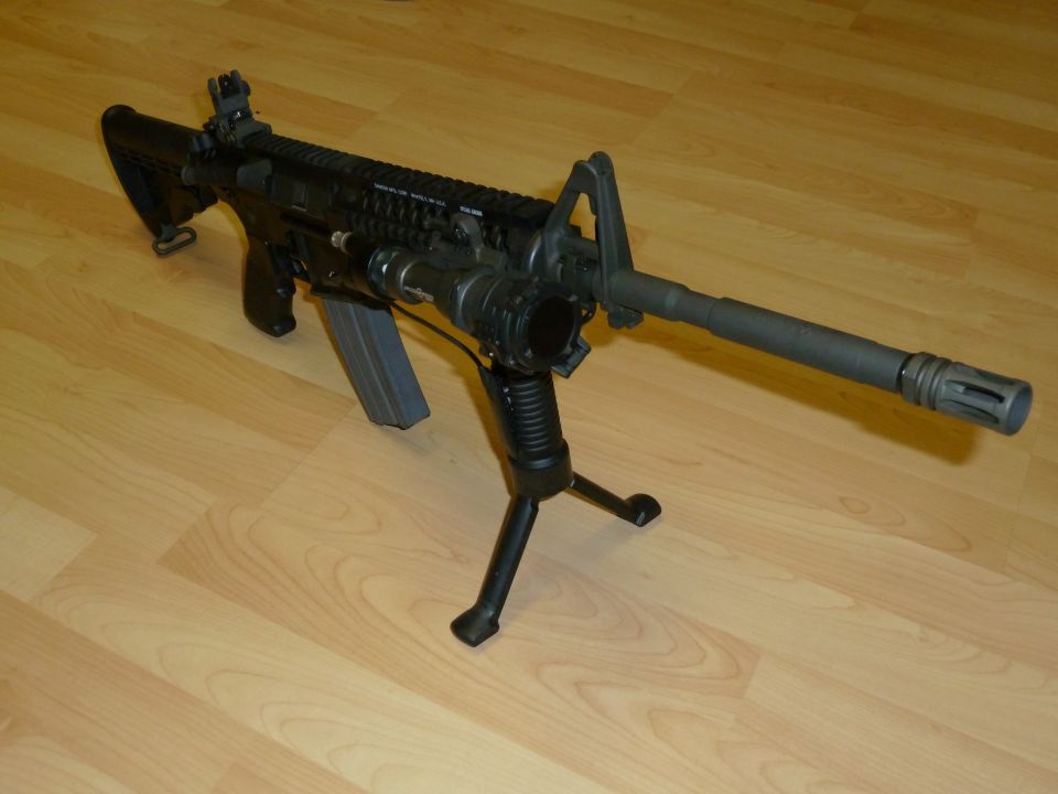 assault rifle with bipod and tactical flashlight mounted on barrel