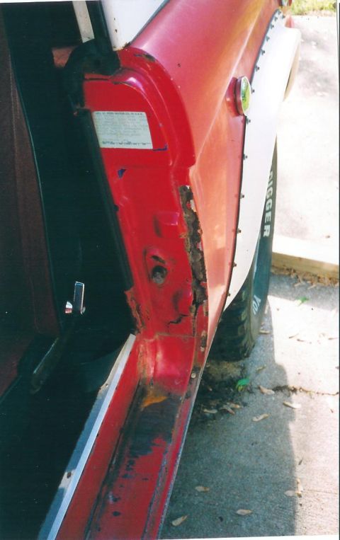 1974 Ford Bronco - Rust damage is visible on the door jamb of this 1974 Ford Bronco, with a white fender flare on the side.