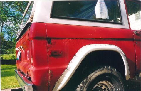 1974 Ford Bronco - Close-up of the rear passenger side of a red Ford Bronco with a white hardtop.