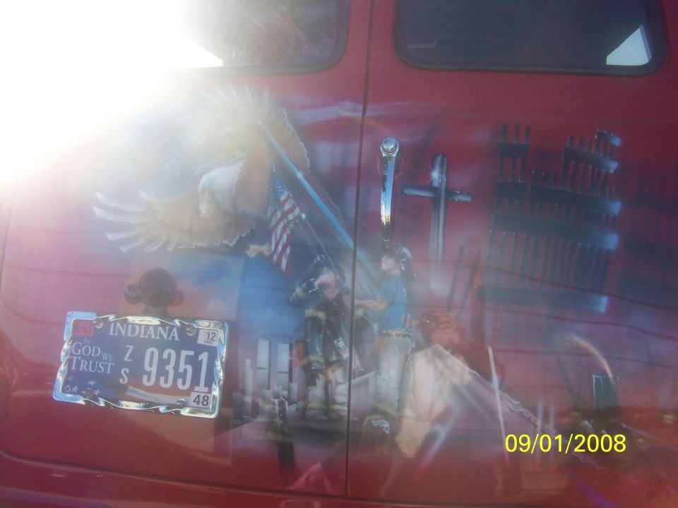 Van with patriotic mural showing an eagle, flag, firefighters, and the Twin Towers. Indiana license plate visible