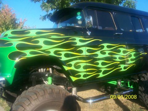 1989 Ford Bronco - A customized SUV with flame decals is shown from the side, a lifted suspension and large off-road tires.