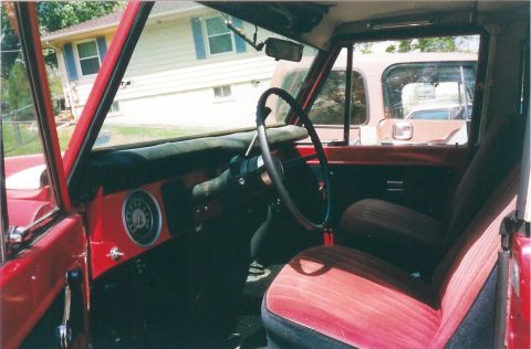 1974 Ford Bronco - Interior view of a red 1974 Ford Bronco, showing the dashboard and seats.
